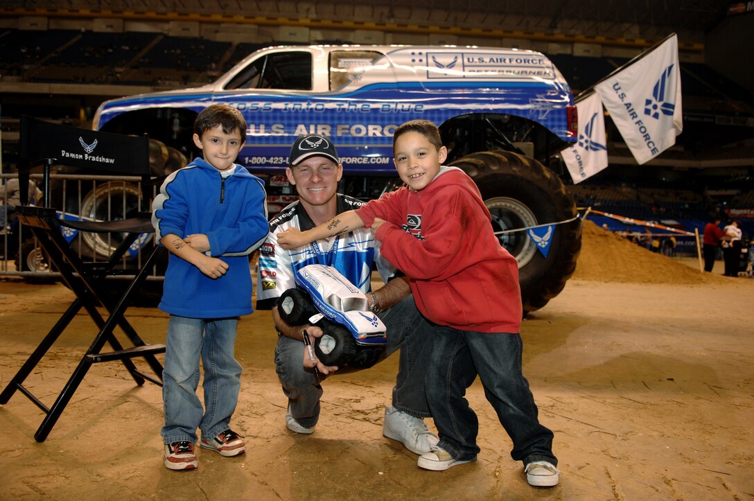 Damon Bradshaw, driver of the Air Force sponsored monster truck Afterburner, poses with young fans Cody Wright (L) and Christian Pena during the Party in the Pits prior to the start of the 2007 Monster Jam in San Antonio, Texas. (US Air Force photo/Master Sgt. Scott Reed)