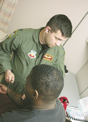 Capt. Alex Keller, flight doctor, checks the blood pressure of his patient, Staff Sgt. Marvelle Canford, a mission controller for the 15th Reconnaissance Squadron, for his initial flight physical. Being a flight doctor means Captain Keller also has to routinely work in the Mike O’Callaghan Federal Hospital during sick call.