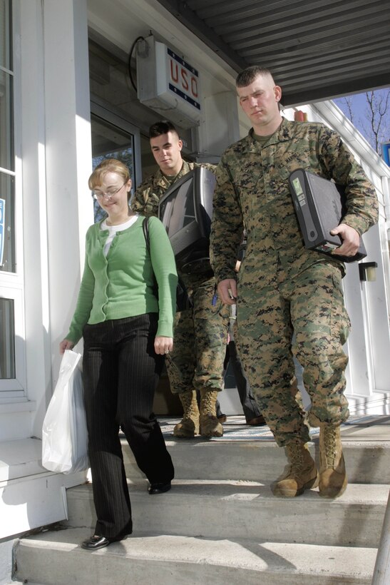 Marines from the 2nd Marine Expeditionary Force, based at Camp Lejeune, N.C., help Josephine Callahan carry her computer to her car. The refurbished computer, one of 250 distributed by Operation Homelink, will help her keep in touch with her husband, Marine Cpl. Bryan Callahan, who recently deployed with Regimental Combat Team 6. Dell donated the computers, which were distributed at the United Service Organizations in Jacksonville, N.C., on Jan. 9. Courtesy photo