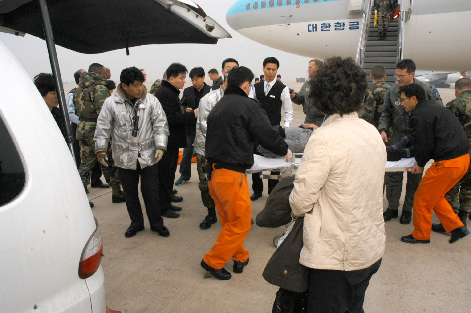 Medical and security personnel rush a 65-year old Korean man needing medical attention to an ambulance after his Korean Airline flight was diverted to Kunsan from Incheon International Airport. The passenger airliner, with 274 people on board, diverted to Kunsan because of poor weather conditions at Incheon. The Korean man was transported to Kunsan Medical Center in downtown Kunsan City. The passengers were offered bottled water as they waited to take off, and the aircraft was refueled by Air Force personnel. (U.S. Air Force photo/Staff Sgt. Nathan Gallahan) 