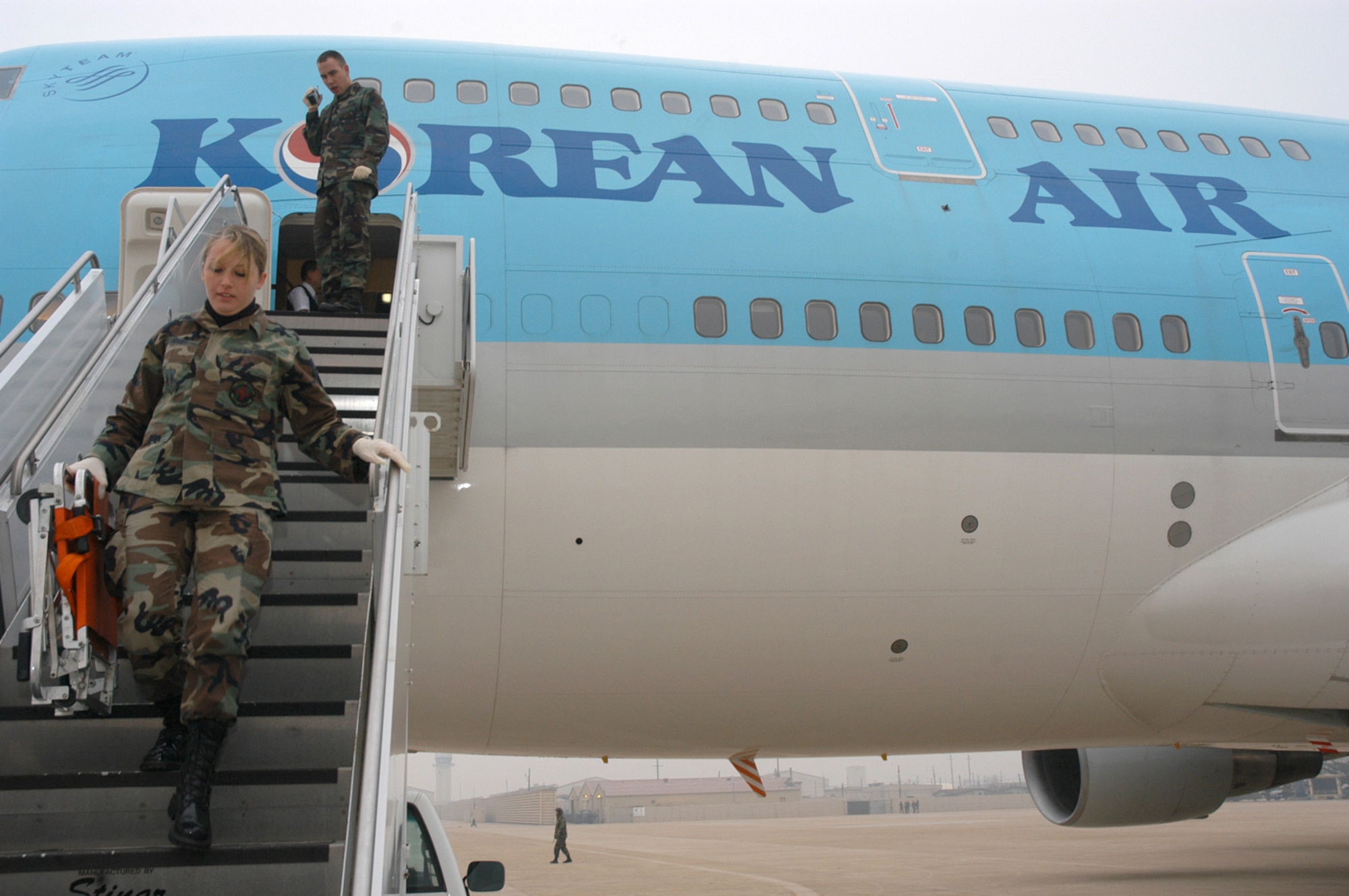 Senior Airman Tonya Jones prepares to receive a 65-year old Korean man needing medical attention at Kunsan Air Base, South Korea. The man was transported to an ambulance after his Korean Airline flight was diverted to Kunsan from Incheon International Airport. The passenger airliner, with 274 people on board, diverted to Kunsan due to poor weather conditions at Incheon. The man was transported to Kunsan Medical Center in downtown Kunsan City. Airman Jones is a medical technician assigned to the 8th Medical Group. (U.S. Air Force photo/Staff Sgt. Nathan Gallahan)