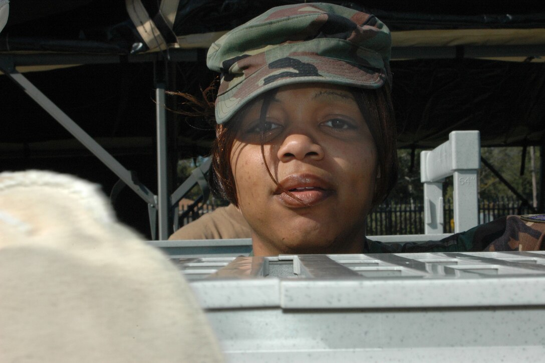 Senior Airman Ebonnie McKeller, 403rd Services specialist, places the final shelf on a spacious storage unit that will house food and equipment used by the unit in the new Single Pallet Expeditionary Kitchen. The 403rd Services Flight set up the kitchen during a recent Unit Training Assembly and even prepared meals for about 30 guests. (U.S. Air Force Photo By Airman 1st Class Tabitha Spinks)