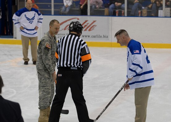EIELSON AIR FORCE BASE, Alaska -- Command Chief Master Sgt. Stephen Ludwig (right) representing Eielson ICEMAN team and Garrison Command Sgt. Maj. Todd Wentland representing Fort Wainwright (FWW) Grizzlies face off for the Honorary puck drop at the Big Dipper Ice Arena, Fairbanks on Jan. 13. Eielson ICEMEN faced off against FWW Grizzlies in the 11th Annual Interior Alaska Armed Forces Ice Hockey Commander's Cup Game. Eielson went on to win the game 8 to 6. 
(US Air Force Photo by Airman Jonathan Snyder)