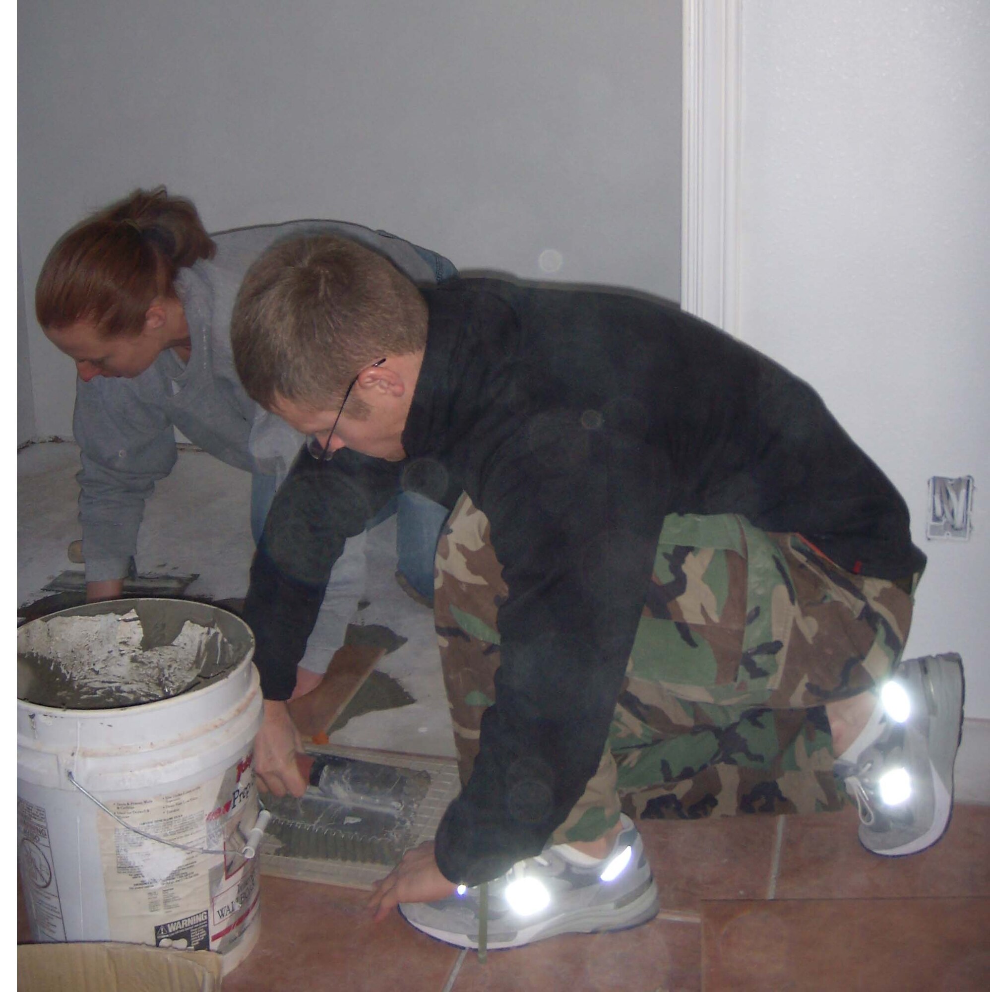 The CGOC began building this home with Habitat for Humanity last summer. Here, lieutenants Kathryn Maitrejean, 49th Logistics Readiness Squadron and Nate DeRohan, 49th Security Forces Squadron, lay tile in a bedroom.  