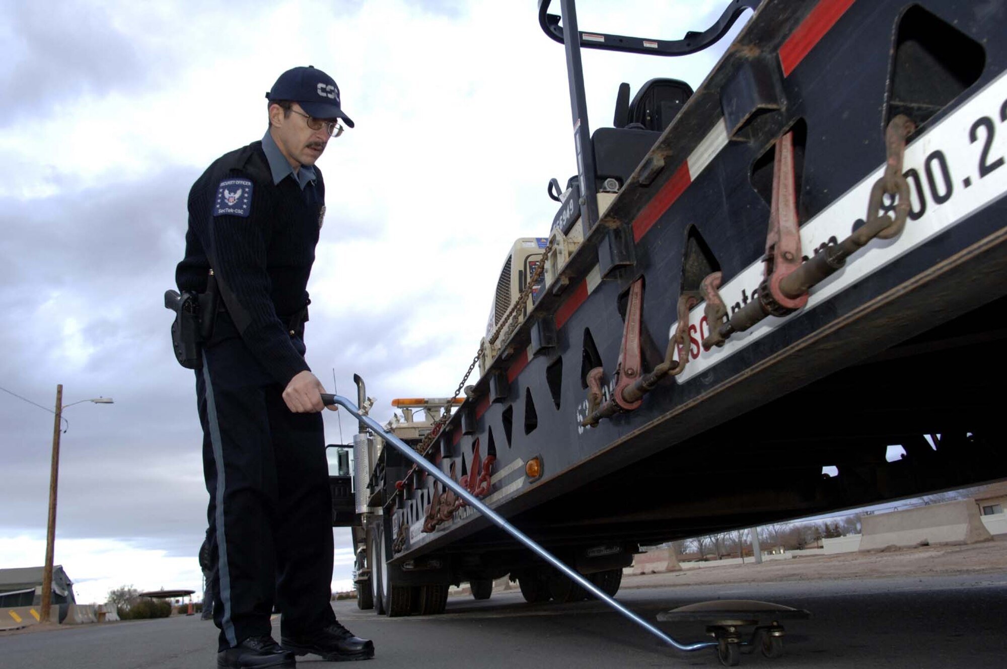 Mr. Wesley Dickey, Holloman gate guard, inspects the undercarriage of a truck for entrance to Holloman. (U.S. Air Force phot by Staff Sgt. Jason Colbert)