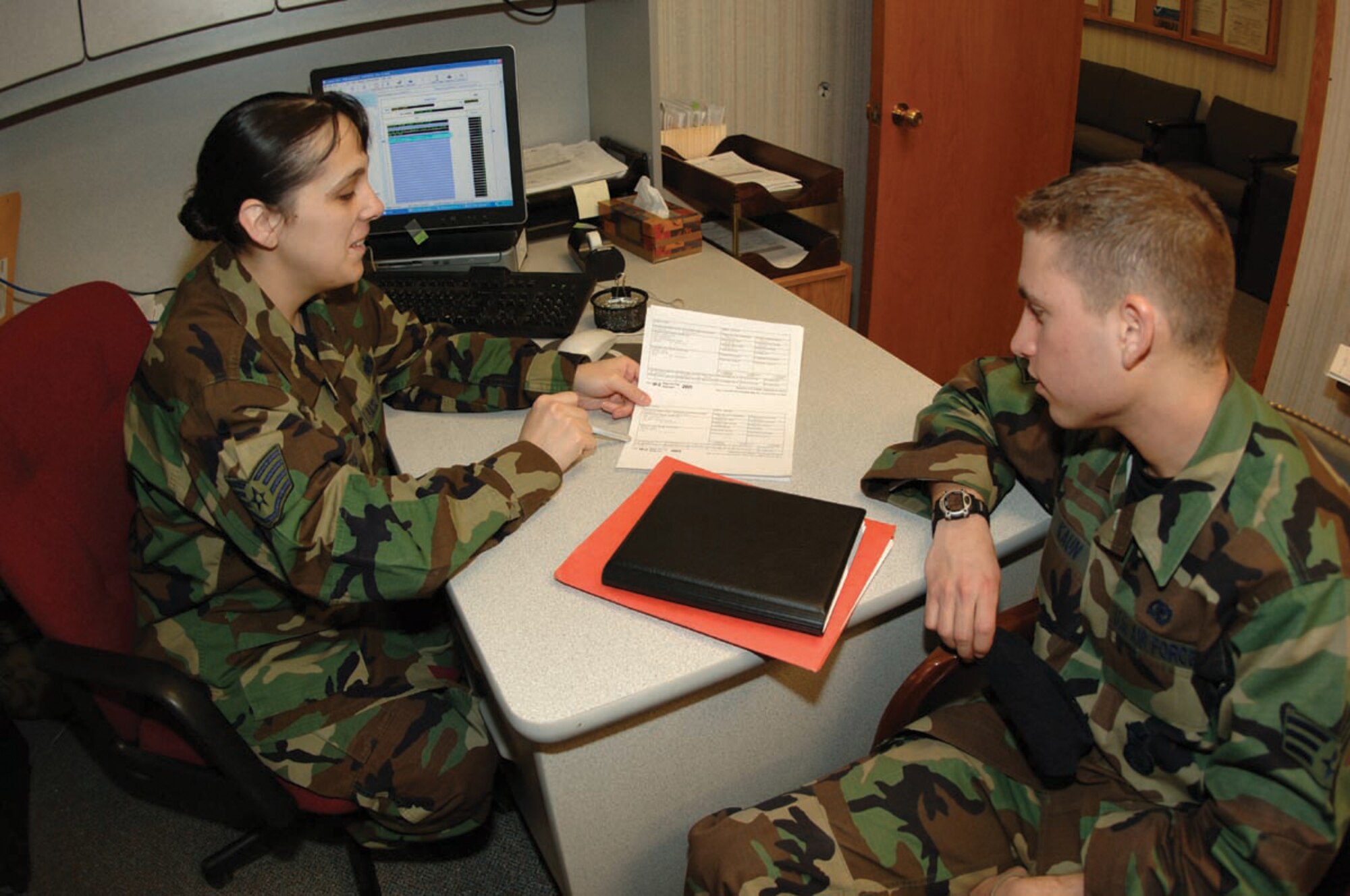 MINOT AIR FORCE BASE, N.D. -- Staff Sgt. Jill Leigh, 5th Bomb Wing Legal Office claims examiner and base tax center volunteer, shows Senior Airman Steven Kaun, 5th Security Forces Squadron, what information can be found on a W-2 Form at the base tax center March 13, 2006. All active-duty service members, retirees, and reservists on active duty for 30 days or more, as well as family members, are eligible for free tax assistance at the base tax center beginning Jan. 22. (U.S.  Air Force photo Airman 1st Class Christopher Boitz)