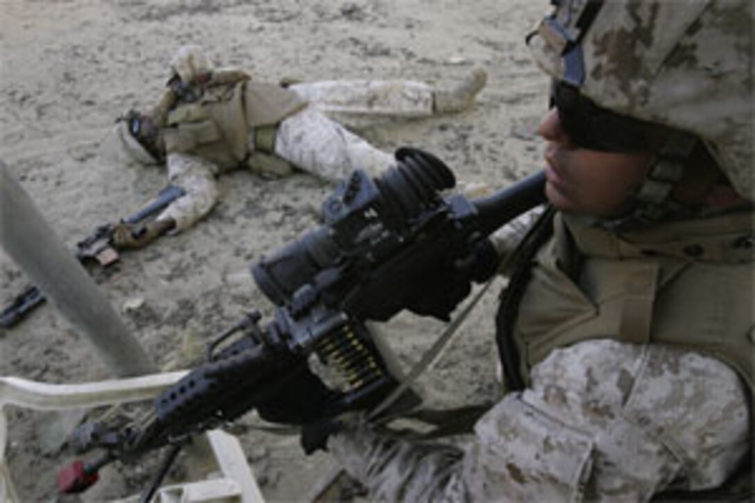 Lance Cpl. Marcos Meza provides security for a "wounded" Marine on the Stu Segall set in Miramar May 8. Meza is a 22-year-old squad-automatic-weapon gunner from San Diego. The studio tried hard to make the situation as realistic as possible, including simulating the death of some of the Marines.