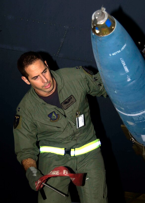 Capt. Joseph McKenna, a B-52 Stratofortress radar navigator assigned to the 23rd Expeditionary Bomb Squadron, checks a Mk-62 "Quickstrike" inert aerial mine prior to takeoff on a counter-sea exercise mission. The 23rd EBS completed a five-day counter-sea exercise Jan. 19, dropping 100 inert mines into the Pacific Ocean over the Marianas Trench. (U.S. Air Force Photo/Senior Master Sgt. Don Perrien)