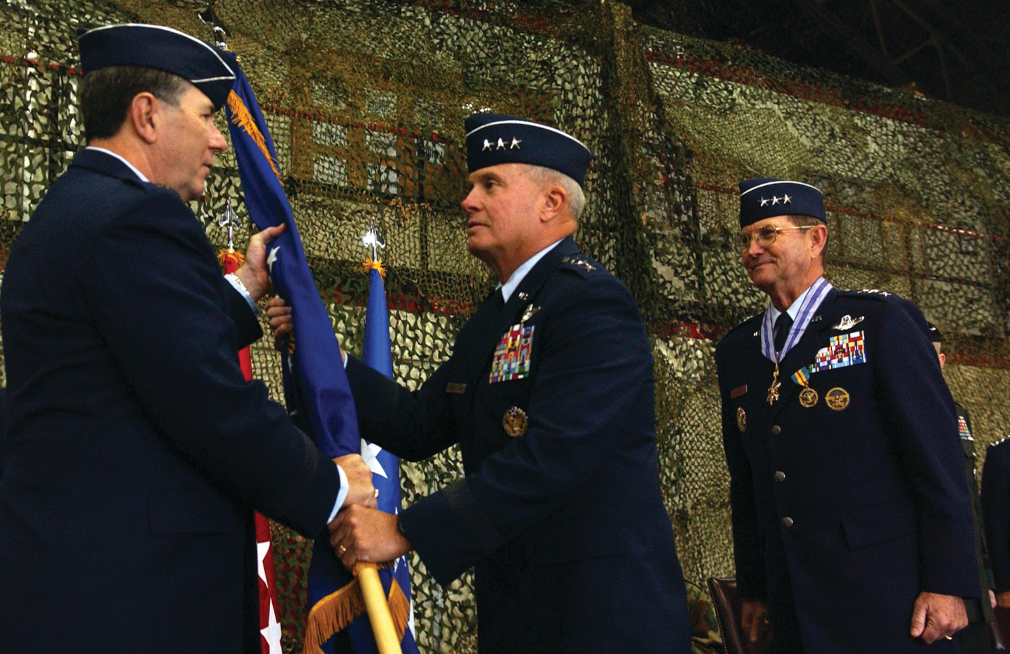 OSAN AIR BASE, Republic of Korea --  Gen. Paul V. Hester, Pacific Air Force Command commander, hands the 7th Air Force guidon to Lt. Gen. Stephen G. Wood, the new 7th Air Force commander, as Lt. Gen. Garry R. Trexler, the former commander, looks on Monday in the 5th Reconnaissance Squadron Blackcat hangar. Lt. Gen. Trexler is retiring after a 36 year career in the Air Force. (U.S. Air Force photo by Senior Airman Eunique Stevens)