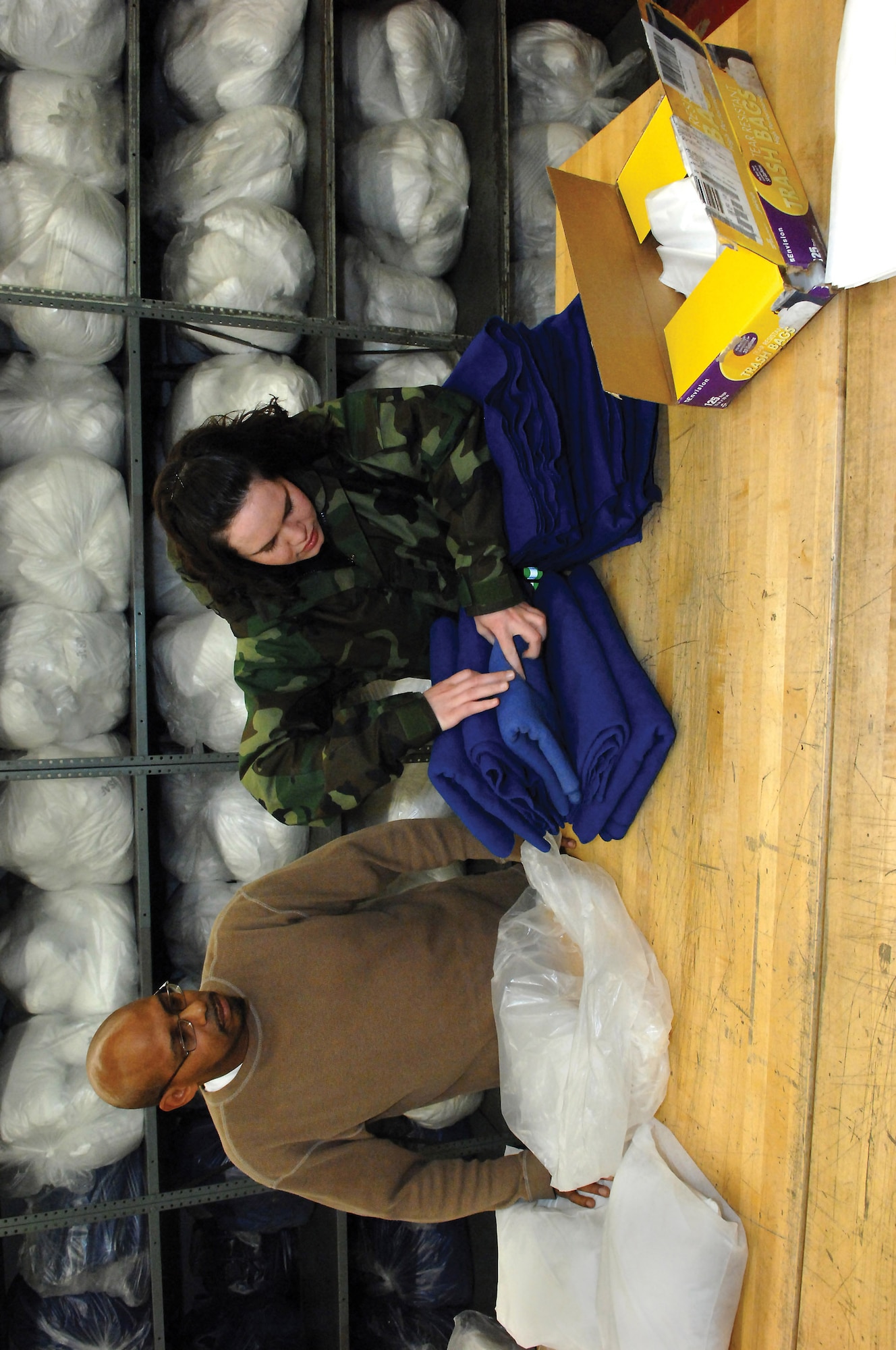 MCCHORD AIR FORCE BASE, Wash.-- 
Wesley Littleton and Airman 1st Class Rebecca Harrison, both from the 62nd Aerial Port Squadron, prepare sets of blankets and pillows in Bldg. 1419 to be used by aircrew and passengers during future missions.
(U.S. Air Force photo/Abner Guzman)
