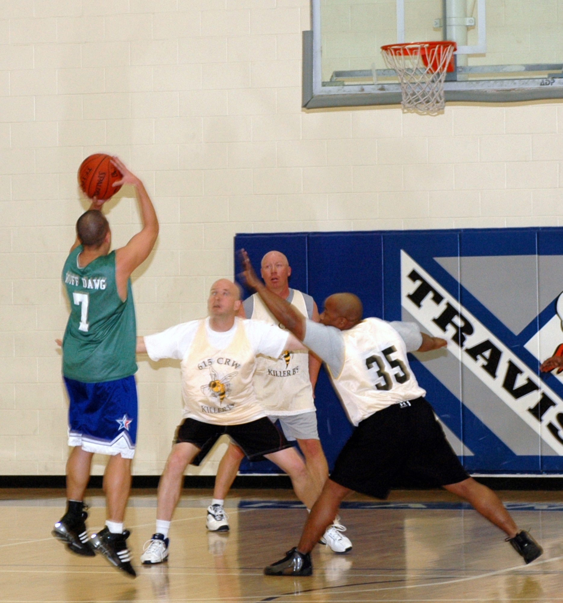 Jonel Relojo, (#7), Log Dawgs point guard shoots a jumps shoot over Killer B's Chris Limbrick, (#35), and Leif Larson. The Log Dawgs defeated the Killer B’s 32-29 Jan. 16 to open the 2007 basketball season. (U.S. Air Force photo by Staff Sgt. Candy Knight)