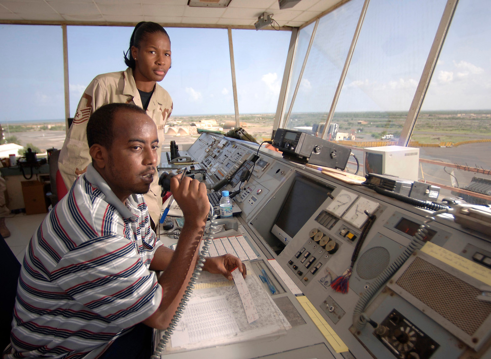 Tech. Sgt. Monique Whitaker works with Mahad Omar, a Djiboutian air traffic controller, on the upper level of the Djibouti Ambouli Tower where she and her Djiboutian counterparts help direct the arrival and departure of an average of 20 military sorties per day. Sergeant Whitaker is an air traffic control liaison assigned to Combined Joint Task Force-Horn of Africa at Camp Lemonier, Djibouti, from Spangdahlem Air Base, Germany. (U.S. Air Force photo/Master Sgt. Scott Wagers)
