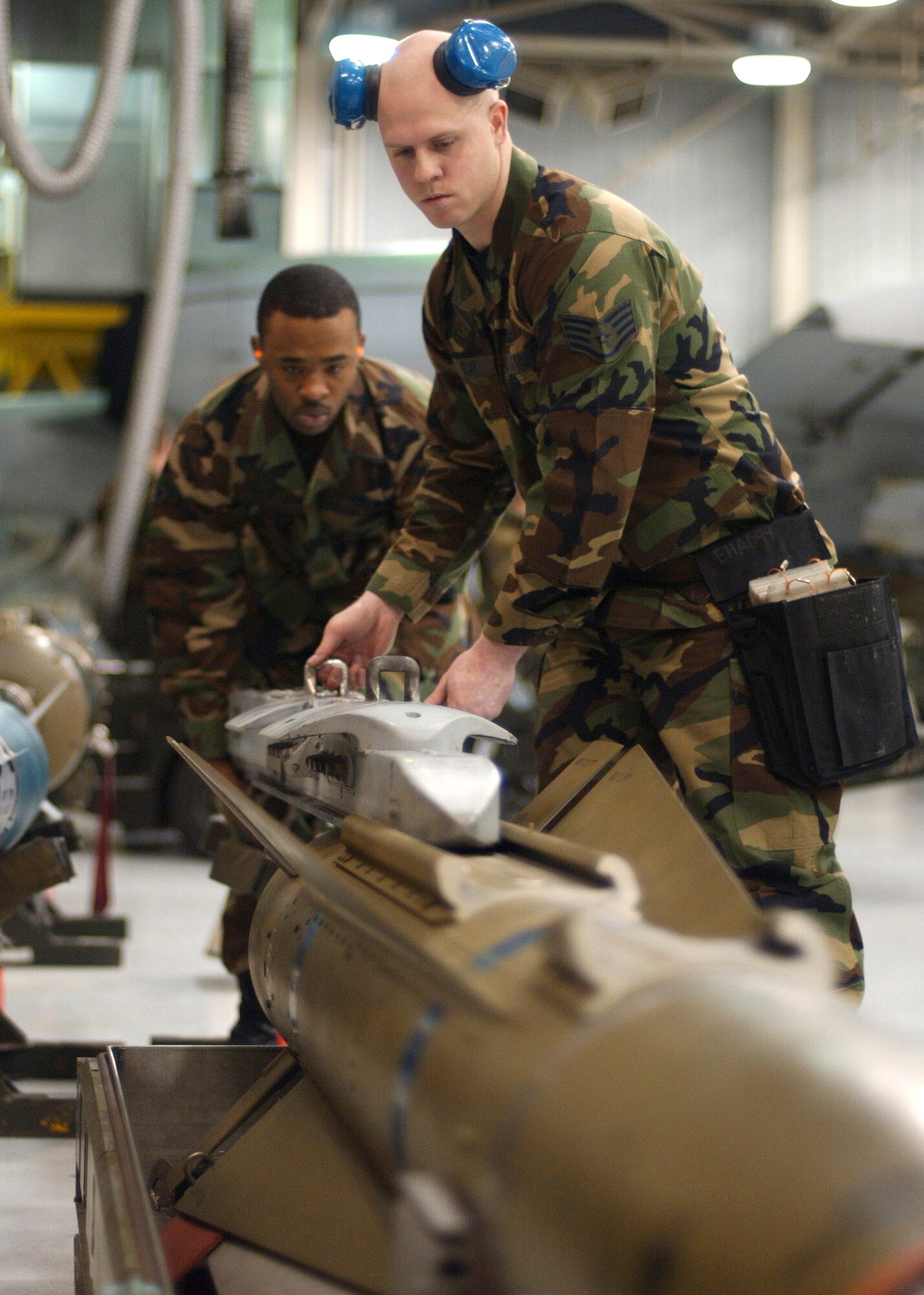 Staff Sgt. Aaron Slay (right) and Senior Airman Corneilius Cutler slide a bracket into place on top an air-to-ground missile to be loaded onto an F-16 Fighting Falcon during the Weapons Standardization Load Crew of the Year Competition Jan. 11 at Eielson Air Force Base, Alaska. The competition evaluates technical proficiency, safety procedures and overall time. The two are assigned to the 18th Aircraft Maintenance Unit. The 18th AMU's overall time was 56 minutes and 37 seconds. (U.S. Air Force photo/Airman Jonathan Snyder) 
