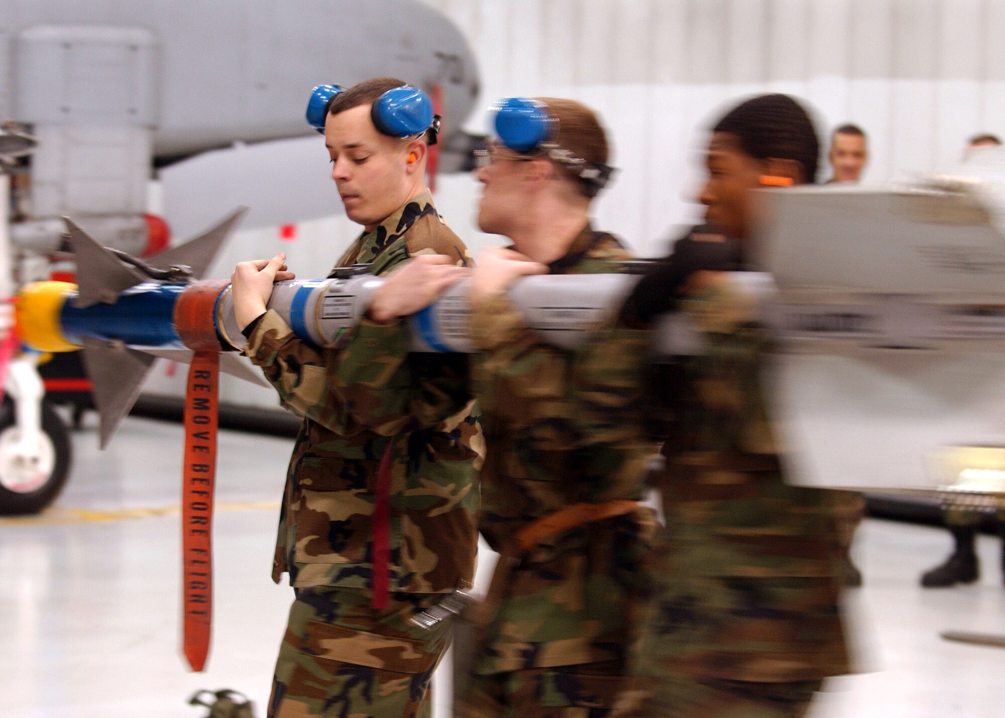 Staff Sgt. Michael Woroniecki (center), Senior Airman Justin Martin (left) and Senior Airman Keitric King transport an AIM-9 Sidewinder missile to be loaded onto an A-10 Thunderbolt II for the Weapons Standardization Load Crew of the Year Competition  Jan. 11 at Eielson Air Force Base, Alaska. The competition evaluates technical proficiency, safety procedures and overall time. The 355th Aircraft Maintenance Unit's overall time was 50 minutes and 17 seconds. (U.S. Air Force photo/Airman Jonathan Snyder)
