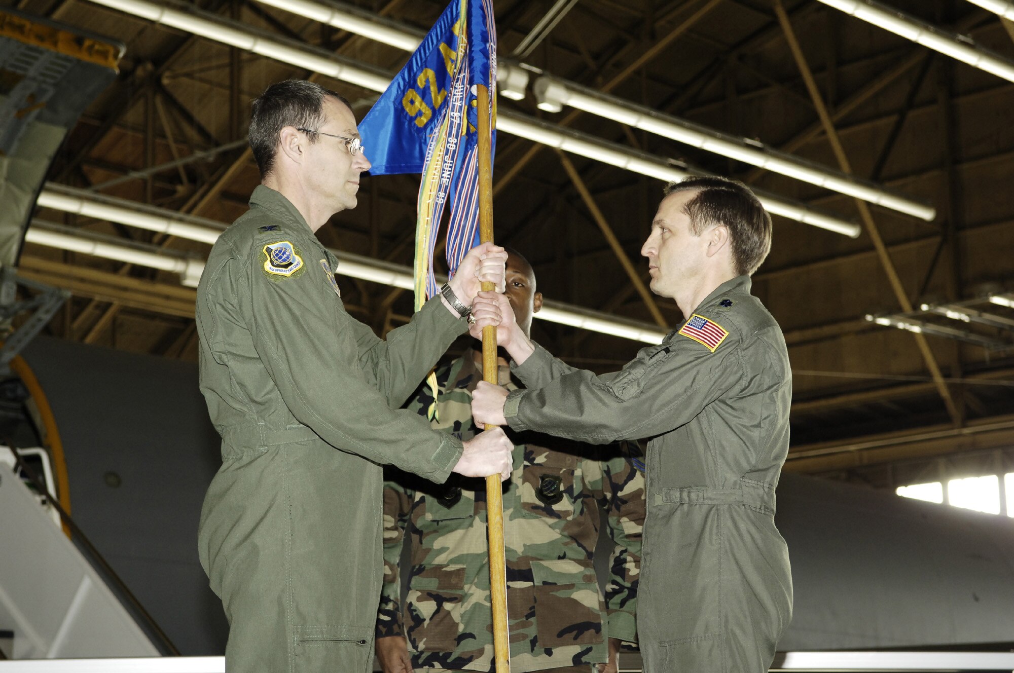 Col. Mark Melville, 92nd Operations Group commander, passes the guidon to Lt. Col. John DeLapp, 92nd Air Refueling Squadron commander, in a change of command ceremony Jan. 12. Colonel DeLapp moved to the 92nd ARS from the Wing Safety Office.