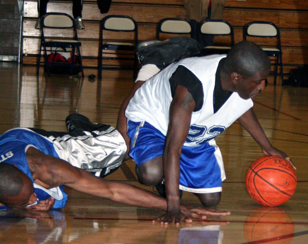 Arthur Calloway (left), 365th Training Squadron, and Kunta Dubose, 82nd Medical Operations Squadron, scramble for the ball during an intramural basketball game Jan. 17 at the Levitow Fitness Center. The 365th TRS won, 52-37 (U.S. Air Force photo/Adrian McCandless.)
