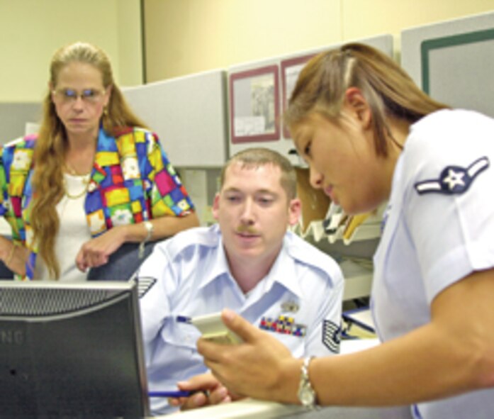 (Photo by TSgt M. Davis) Janie Gould, TSgt Ben Dalton and Amn Amy Hanson of the accounting liaison office, discuss accounts payable items. Their office was recently won the Air Education and Training Command’s Wing Commander’s Incentive Program for the third quarter, and Vance will receive $12,500 for their efforts.