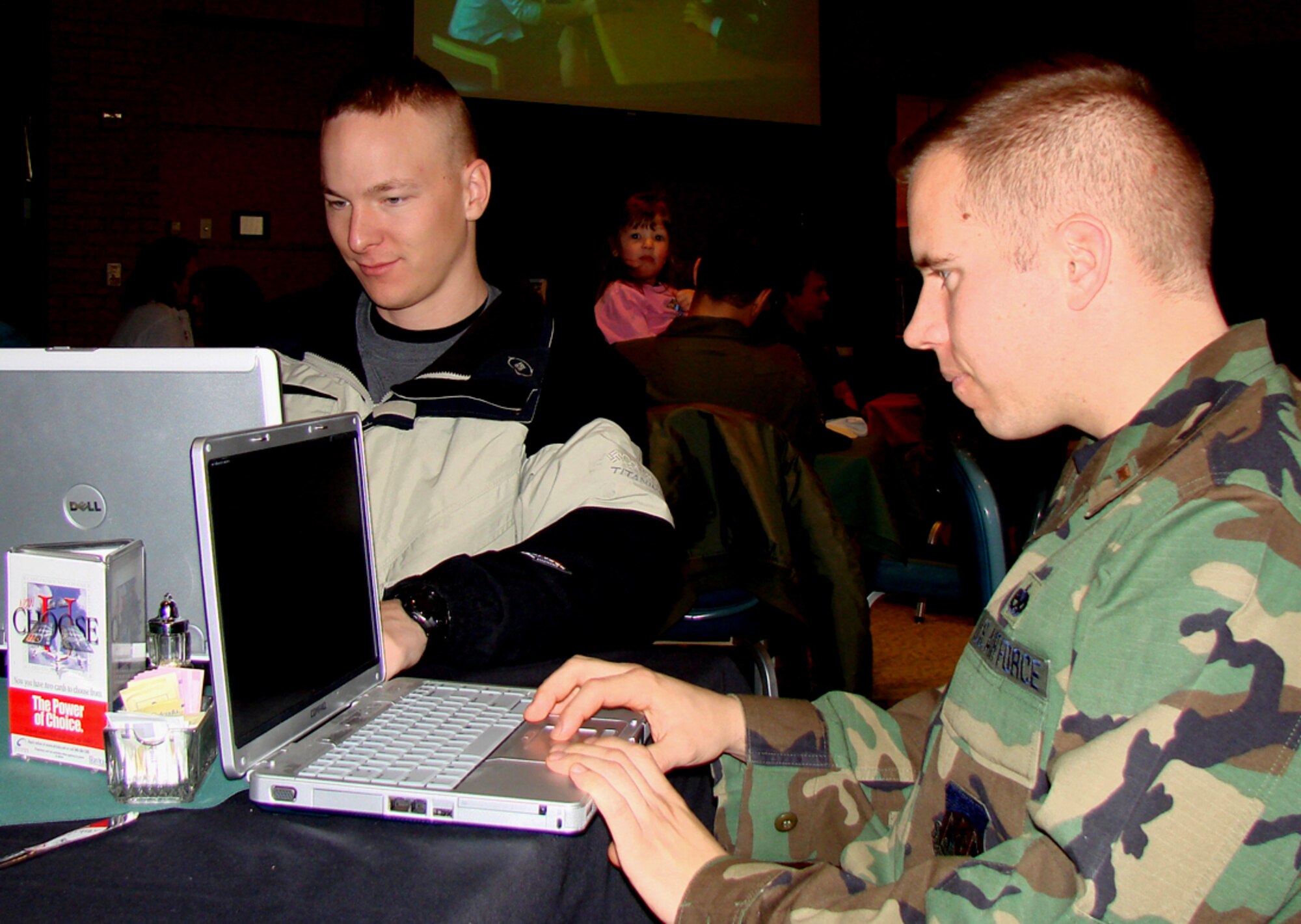Student pilots, 2nd Lts. Curtis Alexander, Class 09-01 and Chris Williams, Class 08-15, take advantage of Vance Air Force Base's newest “hot spot” to check their e-mail. Vance Club manager Carson Campbell said the cyber cafe was established during the club's membership drive to provide members even more benefits. Club members now can stop by during normal club hours with their laptop to conduct personal surfing with free Internet access via a commercial wireless network that is not part of the base official-use-only network. (Photo by 2nd Lt. James Justice) 