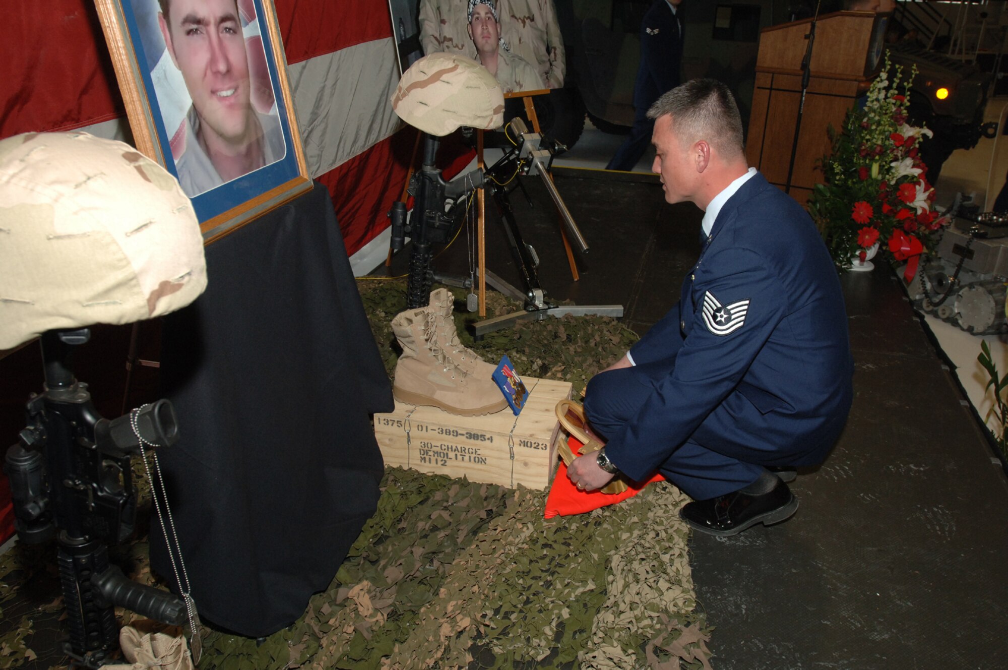 Tech. Sgt. Robert Hood, 775th Civil Engineer Squadron Explosive Ordnance Disposal Flight, puts finishing touches on a memorial display to the three Hill Airmen who were killed in Iraq Sunday. 