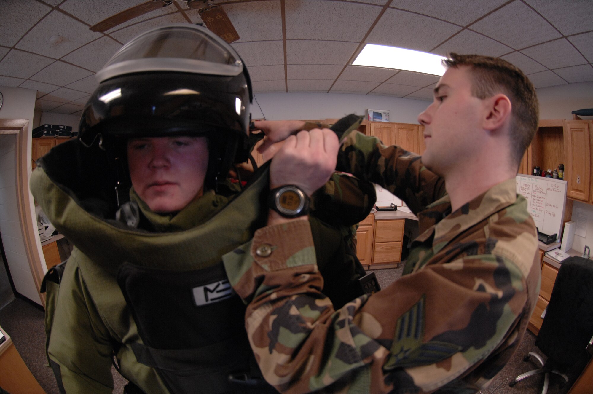 MINOT AIR FORCE BASE, N.D. -- Senior Airman James Tucci, 5th Civil Engineer Squadron Explosive Ordnance Disposal, adjusts a helmet for Jeff Werner, a junior at Mandan High School in Bismarck, N.D., while he tries on an EOD bomb disposal suit during a tour here Jan. 17. The suit, state-of-the-art protective body armor, is specifically designed for EOD members while disposing of ballistic material. (U.S. Air Force photo by A1C Christopher Boitz)
