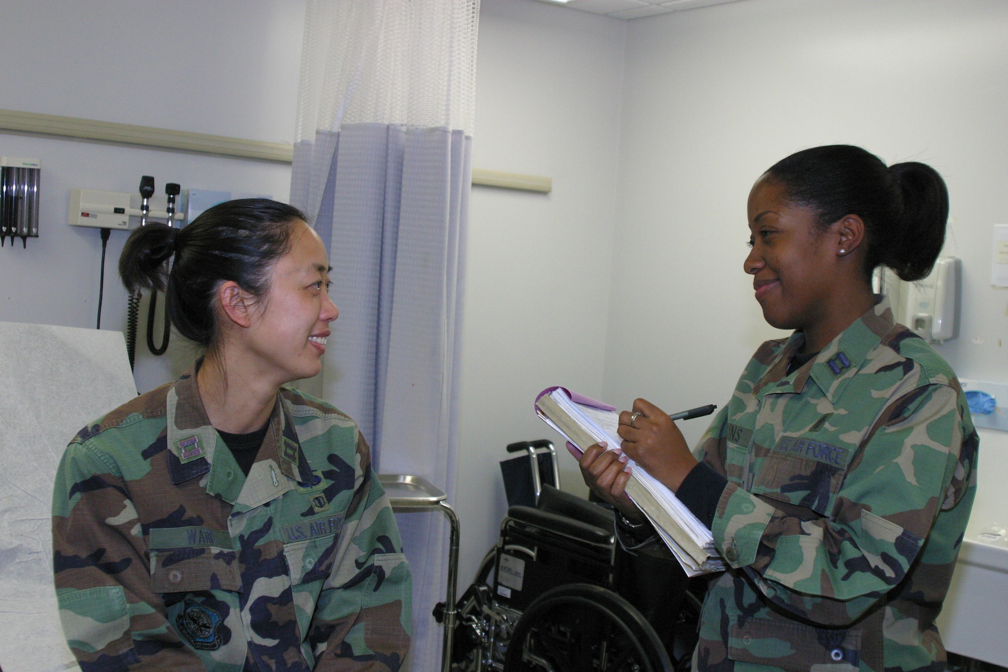 Capt. Danielle Giddins interviews Capt. Claudine Ward about her symptoms at the medical clinic.