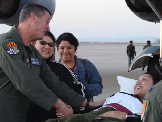 LUKE AIR FORCE BASE, Ariz.  Colonel Timothy Strawther, 56th Operations Group commander, welcomes back to Luke Staff Sgt. Aime Gaona after she received a Purple Heart Dec. 19, after being hit by a sniper’s bullet in her right femur. Sergeant Gaona was a weapons intelligence team member of the 732nd Expeditionary Civil Engineer Squadron deployed from Luke to Balad, Iraq. She returned to Luke directly from Andrews Air Force Base via a C-17. She was also welcomed back by Brig. Gen. Tom Jones, 56th Fighter Wing commander, and a crowd of family, friends and co-workers.  