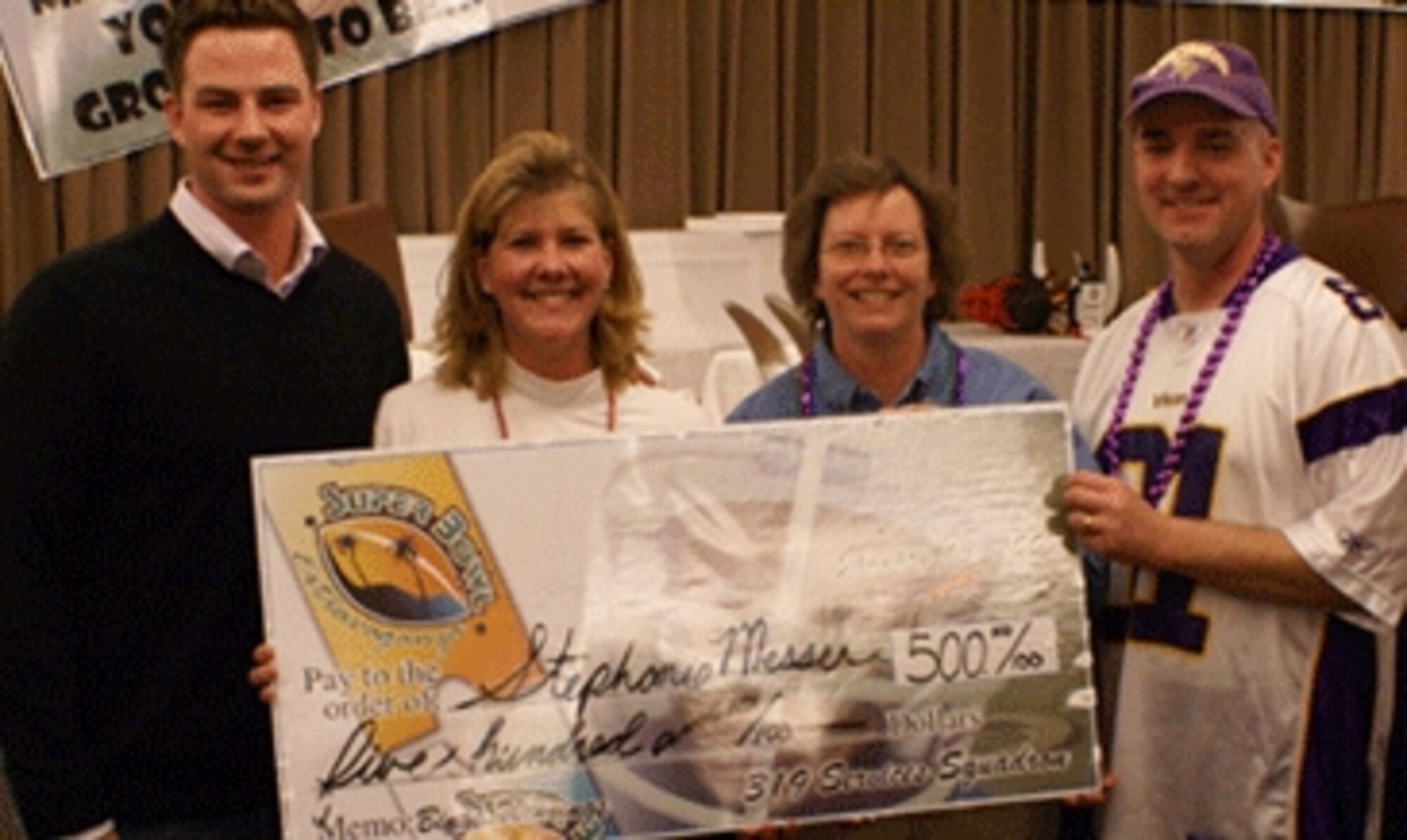 Minnesota Viking quarterback, Mr. Brooks Bollinger.  Bollinger, Col. Diane Hull, 319th Air Refueling Wing commander, and Maj. Paul Swenson, 319th Services Squadron commander, present Tech. Sgt. Stephanie Messer, 319th Maintenance Operations Squadron, with the Super Bowl tickets. Sergeant Messer was the grand prize winner of the Super Bowl Extravaganza. (photo/Michael Holcomb)