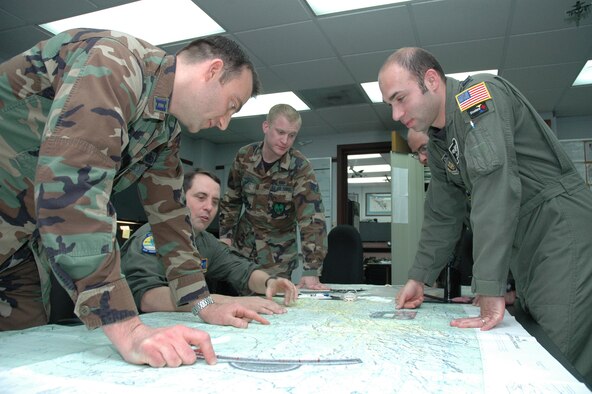 YOUNGSTOWN AIR RESERVE STATION, Ohio—Air Force Reservist Capt. John Gaffney, an Intelligence Officer with the 910th Airlift Wing, points out areas of enemy activity to Tactics Chief Lt. Col. Brian Chambers during a mission planning exercise.  The intelligence career field is one of a vast number of specialities available in the Air Force Reserve.  U.S. Air force photo/Tech.Sgt. Ken Sloat. 