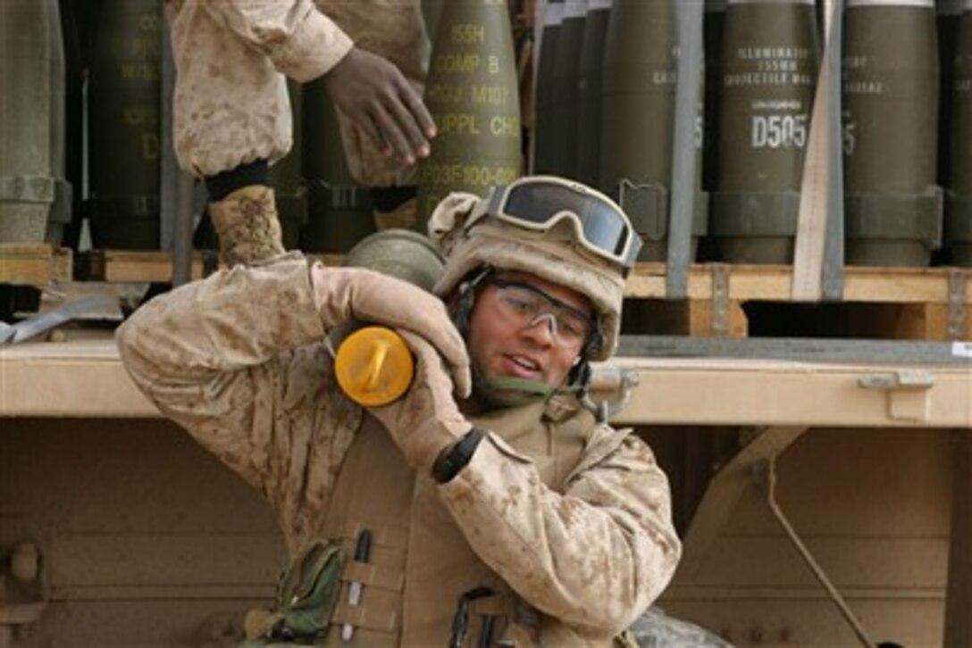 A U.S. Marine carries a round in preparation to fire a 155mm howitzer near Baghdad, Iraq, on Jan. 6, 2007.  The Marines are with Lima Battery, 2nd Battalion, 13th Marine Regiment.  