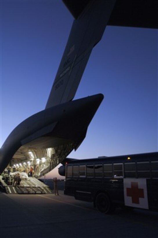 Crewmembers aboard a U.S. Air Force C-17 Globemaster III aircraft prepare to offload wounded personnel from Balad Air Base, Iraq, into a 386th Contingency Aeromedical Staging Facility bus in Southwest Asia on Jan. 17, 2007.  