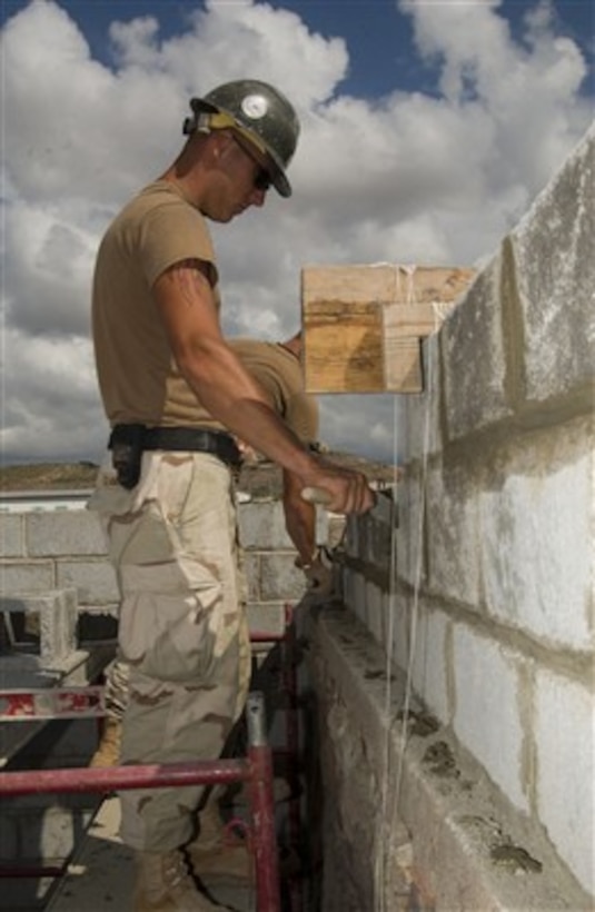 U.S. Navy Seabee Petty Officer 3rd Class Bradley Clark smoothes mortar as he builds a wall for a girl's school dormitory in Tadjoura, Djibouti, on Jan. 10, 2007.  Clark is a Navy builder with Naval Mobile Construction Battalion 5 attached to Combined Joint Task Force-Horn of Africa. 