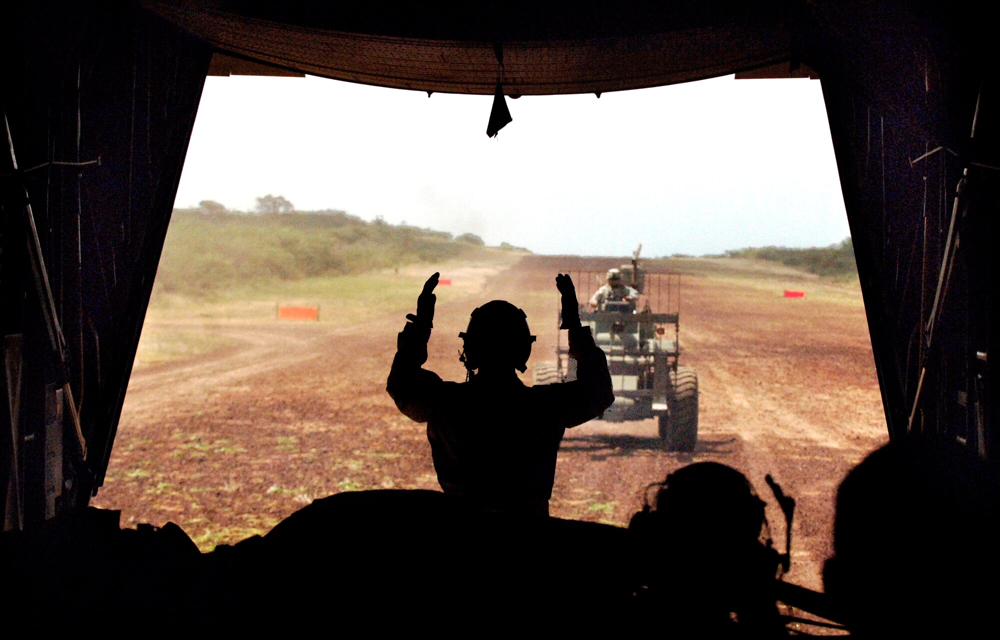 Loadmaster Airman 1st Class Bret Oyler directs Guam Army National Guardsman Specialist Rick Naputi towards the rear of the aircraft for cargo removal. Airman Oyler is deployed to the 737th Expeditionary Airlift Squadron, Southwest Asia, from Elmendorf Air Force Base, Alaska. (U.S. Air Force photo/Master Sgt. Scott Wagers)