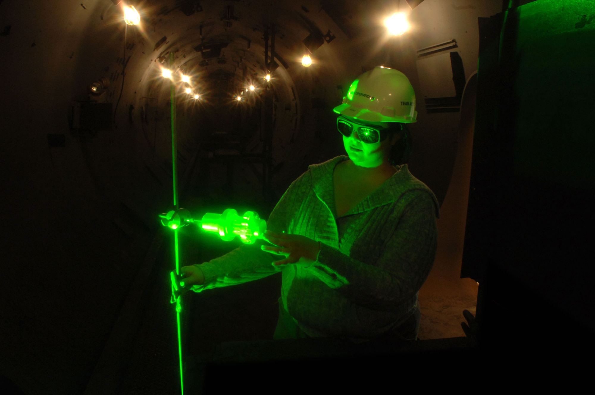 Katie Stephens aligns a projectile with a laser at the Arnold Engineering Development Center's large Hypervelocity Ballistic Range G facility at Arnold Air Force Base, Tenn. The laser assesses the condition of a projectile during a specific stage of flight. The Range G launcher is the largest, two-stage, light-gas gun system in the United States that can launch extremely high-fidelity missile simulations at hypervelocity speeds. Ms. Stephens is an optical diagnostics group engineer with Aerospace Testing Alliance's technology and analysis branch. (U.S. Air Force photo/Rick Goodfriend) 
