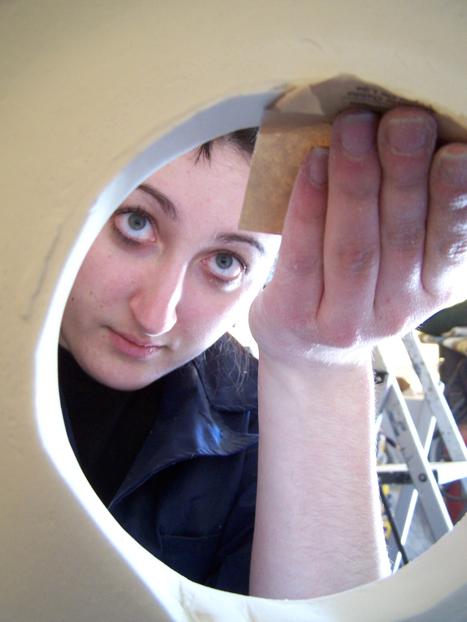 Senior Airman Christy Cadle sands the inside of a porceline light fixture in a home being restored in Bay St. Louis, Miss. The home was damaged by Hurricane Katrina more than a year ago. Airman Cadle is a maintenance specialist assigned to the 354th Aircraft Maintenance Squadron from Eielson Air Force Base, Alaska. She was one of five Airmen who travelled from Eielson AFB to the Gulf coast to repair Hurricane Katrina-damaged homes. (U.S. Air Force photo/Senior Airman Anthony Nelson)
