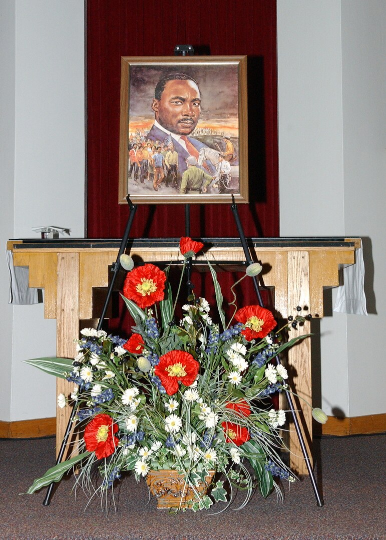 A painting of Dr. Martin Luther King Jr. and a floral tribute displayed on the altar helped bring focus to the members of Team Lackland who came together for a commemorative service Jan. 11 at Freedom Chapel honoring the late Dr. King. Guest speaker for the service was a longtime Lackland Air Force Base, Texas, choir director, Bradley Scott, Ph.D., senior education associate for the Intercultural Development Research Association. (USAF photo by Alan Boedeker)                            