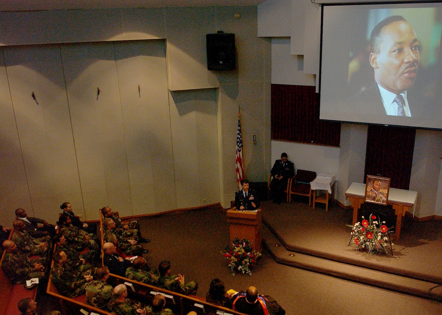 As a photo of the late civil rights leader is projected on the altar behind him, Brig. Gen. Darrell Jones, then the commander of the 37th Training Wing at Lackland Air Force Base, Texas, welcomes members of Team Lackland to a commemorative service Jan. 11, 2007, at Freedom Chapel honoring Dr. Martin Luther King Jr. Guest speaker for the service was a longtime Lackland choir director, Bradley Scott, Ph.D., senior education associate for the Intercultural Development Research Association. (USAF photo by Alan Boedeker)                               