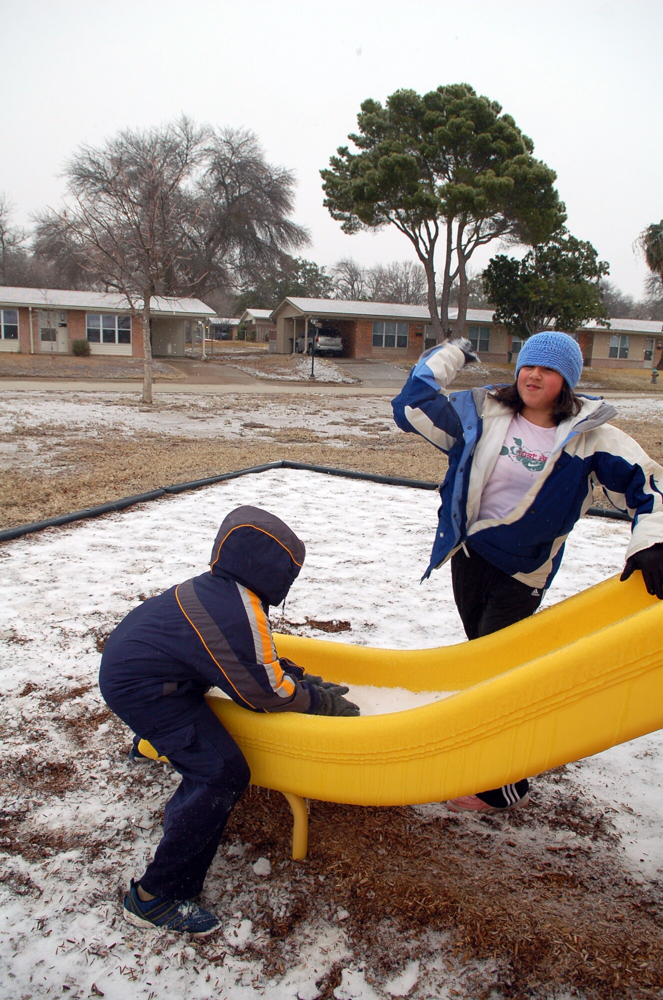 LAUGHLIN AIR FORCE BASE, Texas -- Felicia O’Kane, daughter of Tech. Sgt. Melissa and Kelly O’Kane, winds up to bombard Ryan Gorshe, son of Master Sgt. Tim and Carmen Gorshe, with a snowball at a playground in base housing Tuesday.  (U,S, Air Force photo by Staff Sgt. Austin May)