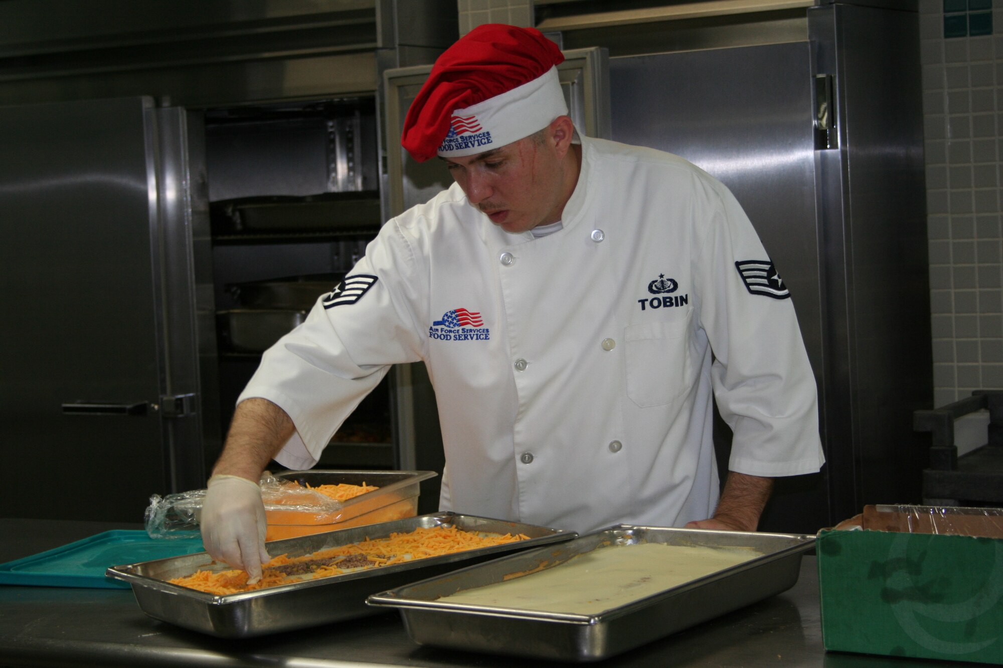 Staff Sgt. Joshua Tobin adds a decorative touch to a buffet entree at the Reef Dining Facility. (U.S. Air Force Photograph by Staff Sgt. Kelly Ogden)
