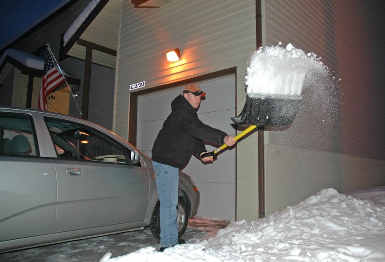 Staff Sgt. Phillip Bridges shovels the driveway of his new home Jan. 17. Thanks to a total basewide effort at Eielson Air Force Base, Alaska, Sergeant Phillips' family was one of 241 successfully relocated from the on-base Sprucewood Homes development to viable on- and off-base residences before the harsh Alaska winter rolled in. Sergeant Bridges is assigned to the 354th Logistics Readiness Squadron. (U.S. Air Force photo/Senior Airman Justin Weaver)