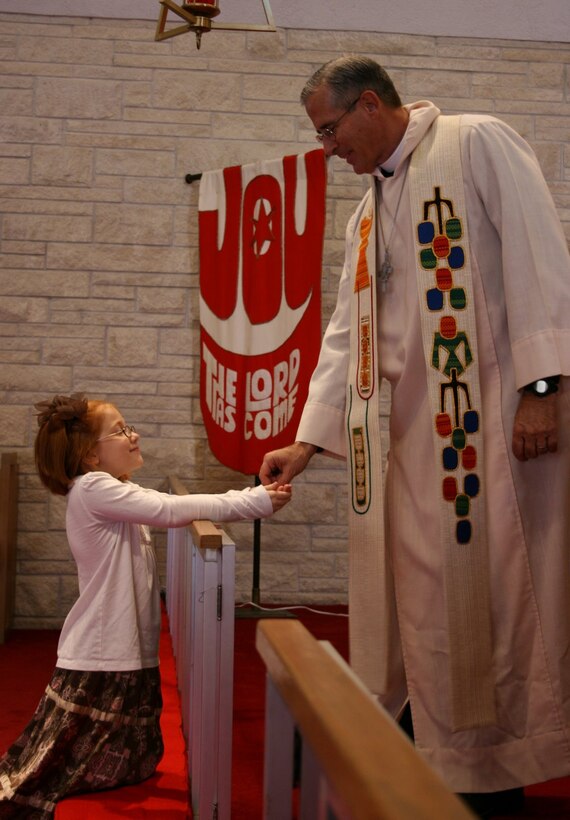 Chap. Fulton serves his granddaughter Morgan,8, her first communion during his first service at St. Paul’s Lutheran Church after his deployment. (Courtesy Photo)