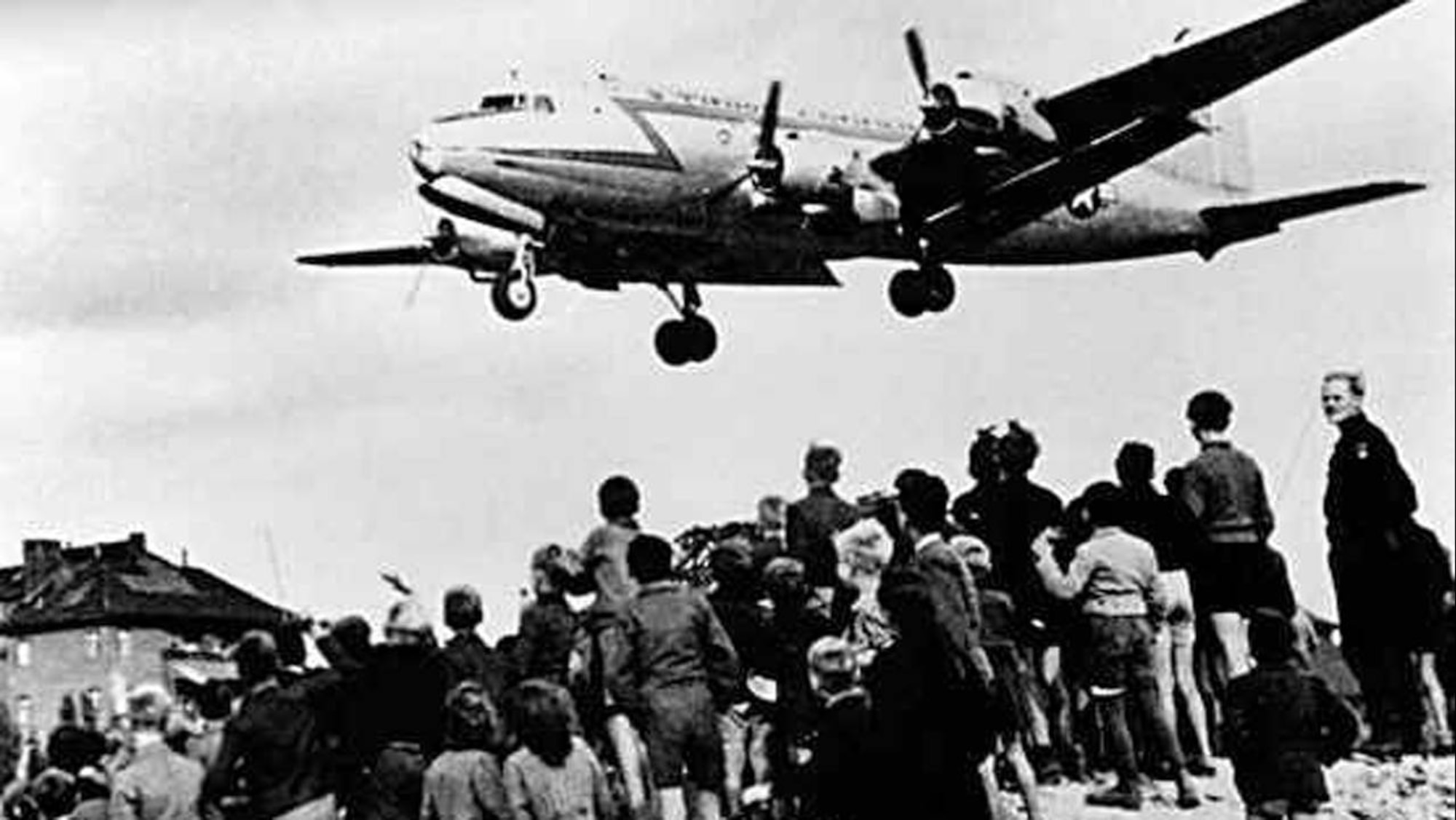 West Berliners watch as a U.S. cargo plane delivers desperately needed supplies during the Berlin Airlift.  (File photo)