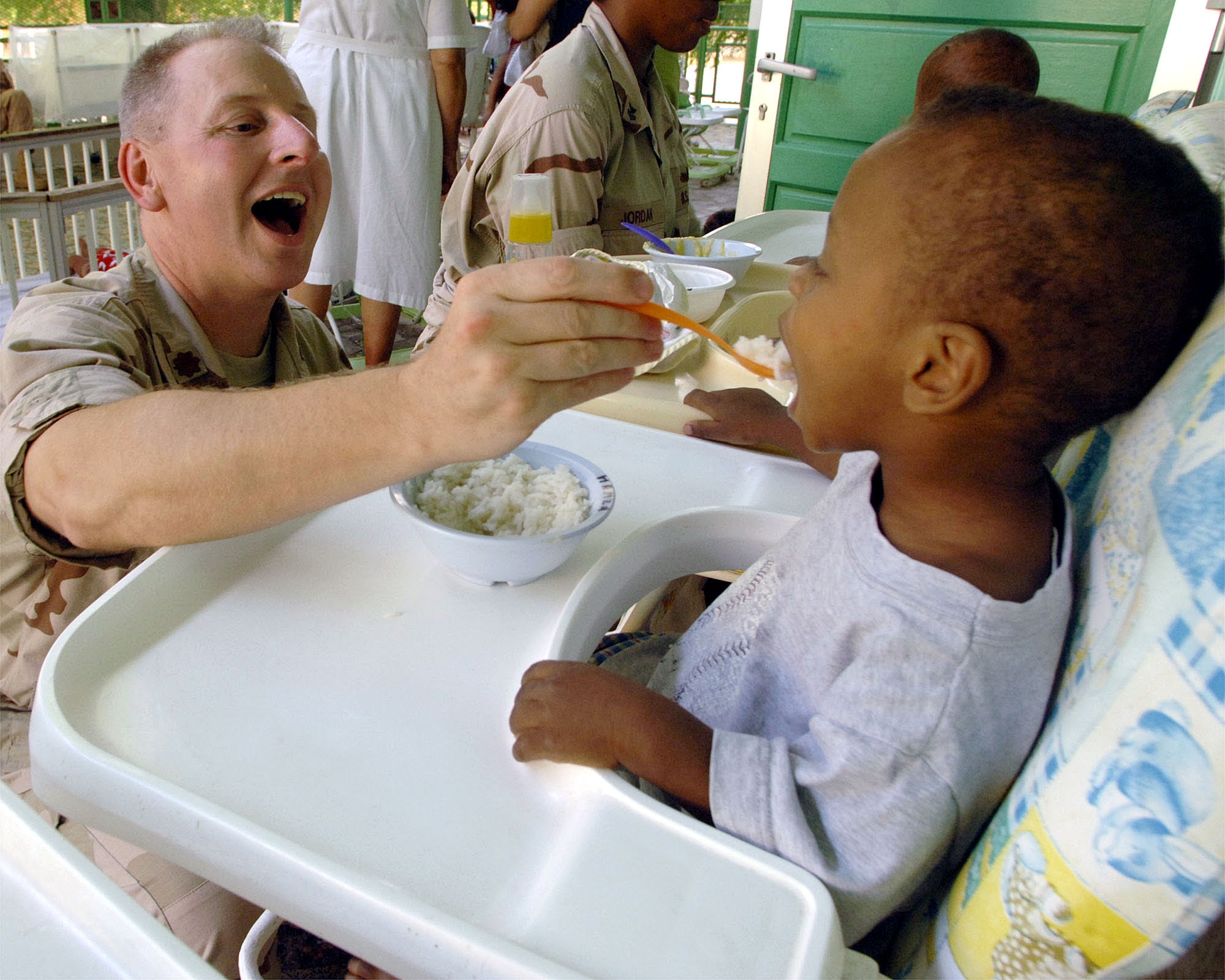 Chaplain (Maj.) Steven O'Brien feeds an orphaned toddler mashed potatoes at the Franciscan Missionaries of Notre Dame Baby Orphanage in Djibouti City, Djibouti. Chaplain O'Brien deployed to Camp Lemonier, Djibouti, from the 4th Air Force at March Air Reserve Base, Calif. The Camp Lemonier chapel staff arranges visits to this orphanage three times a week. (U.S. Air Force photo/by Staff Sgt. Francesca Popp) 

