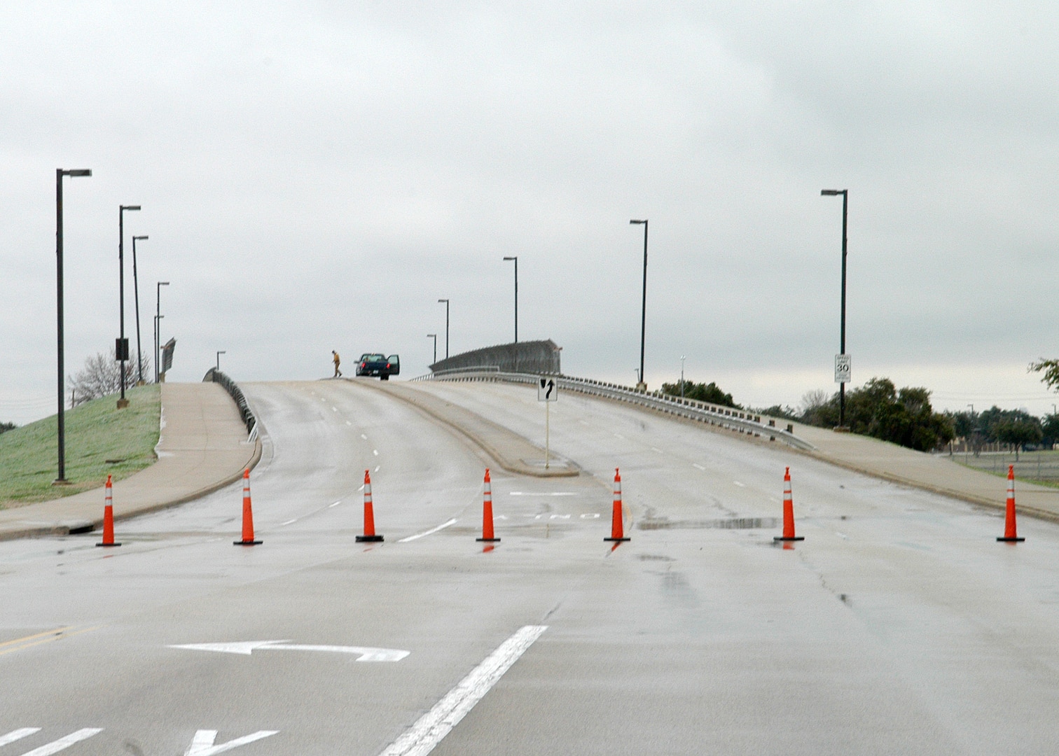 An ice-slick Truemper Street bridge over Military Drive on Lackland Air Force Base, Texas, is blocked off with cones in this view looking east Jan. 17, 2007. Road conditions such as these existed all across the San Antonio area, resulting in the base closure for all but essential personnel Jan. 16 and 17. "Safety for Team Lackland was paramount in making the decision to close the base," said Brig. Gen. Darrell Jones, then the 37th Training Wing commander. "We have a lot of dedicated people on this base who wanted to come to work, but I'd rather have them home for a day or two, waiting out the weather, than risk being in an accident." (USAF photo by Alan Boedeker)                              