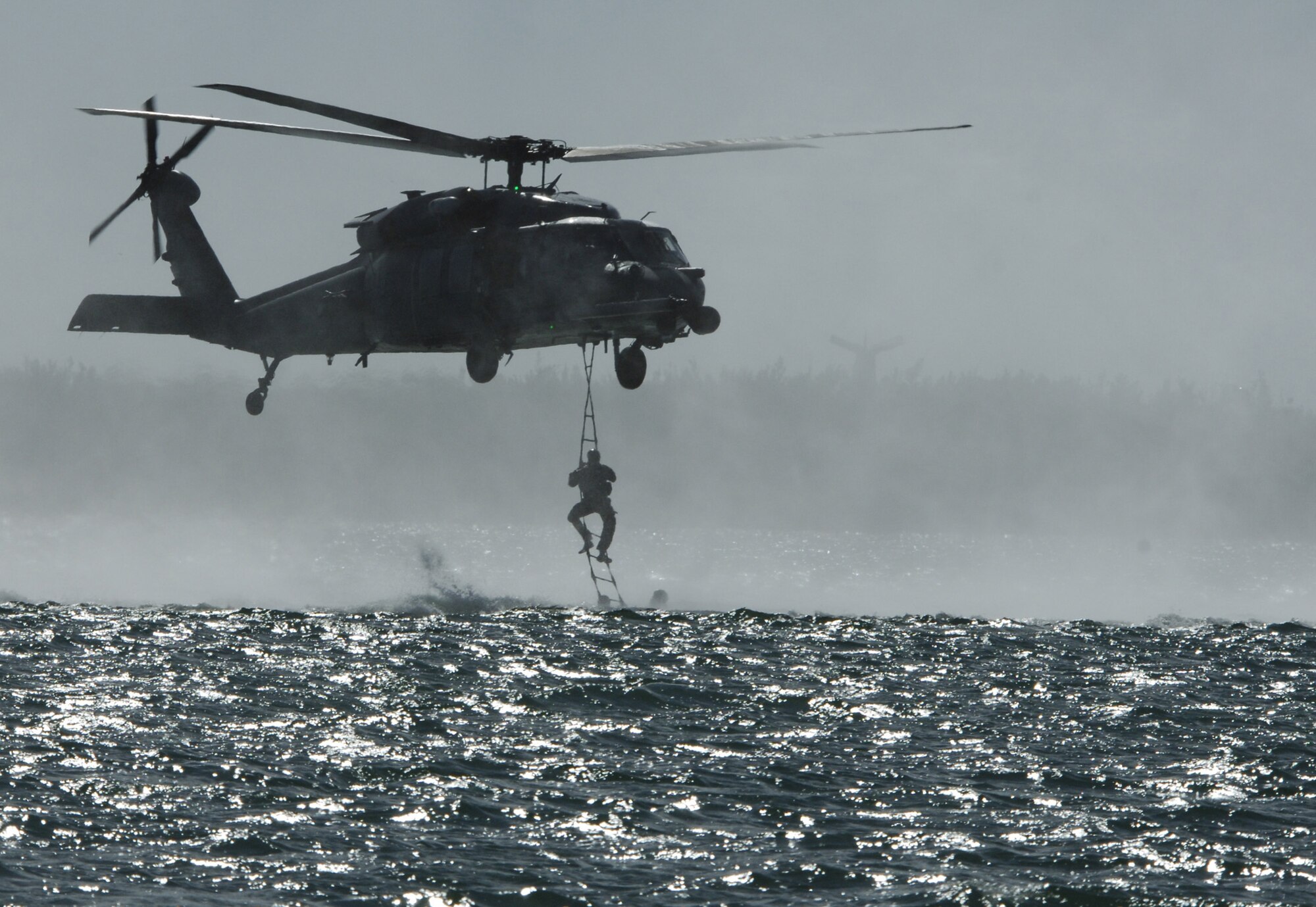 An HH-60G Pave Hawk from the 41st Rescue Squadron hovers over a target area before dropping pararescuemen and soldiers during water survial and extraction training Jan. 9 at Key West Naval Air Station, Fla. The 41st and 38th Rescue Squadrons worked with U.S. Army Special Forces to perform several interservice activities. (U.S. Air Force photo by Senior Airman Javier Cruz)