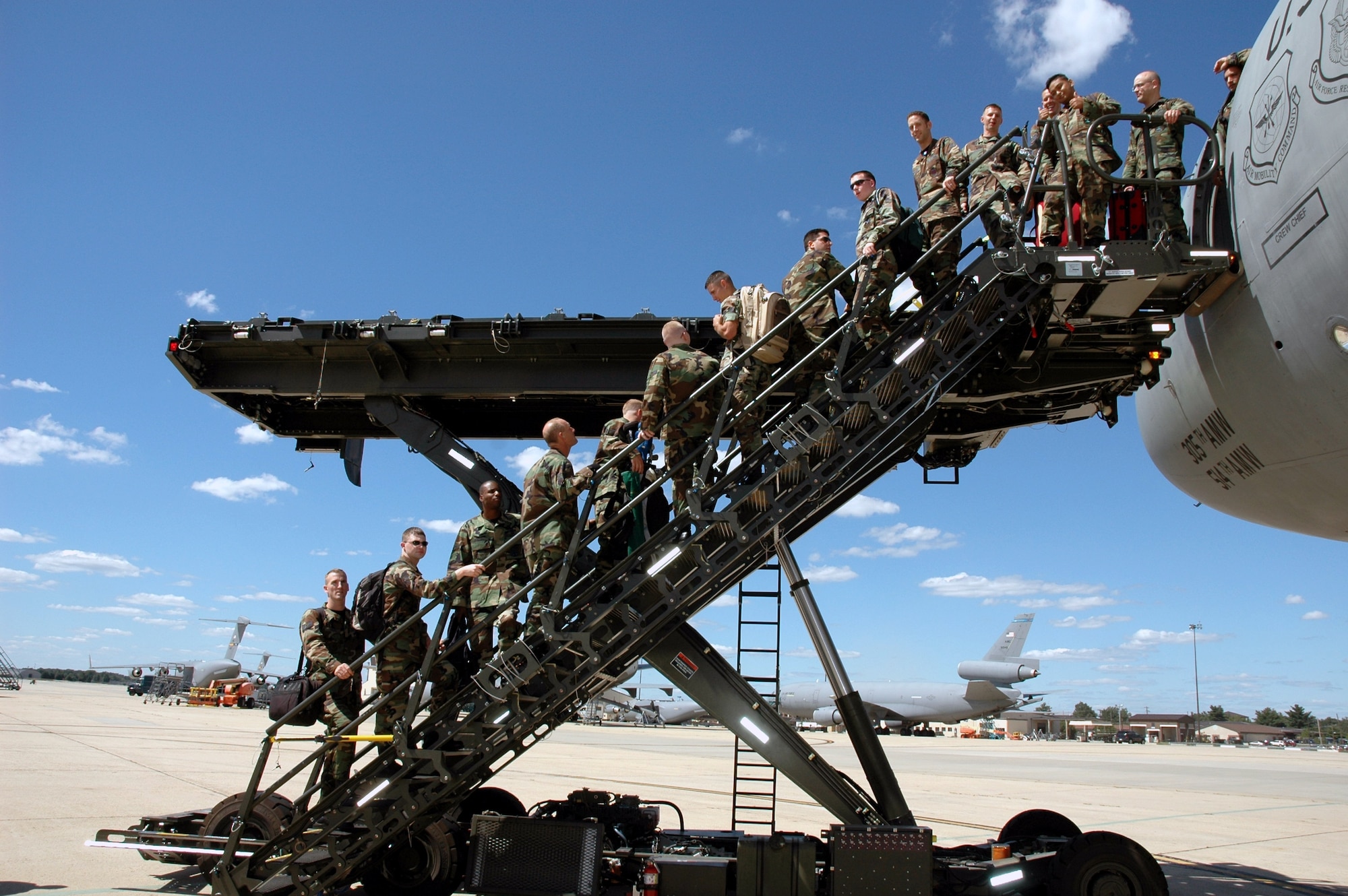 U.S. Air Force Airmen use the aircraft stairs portion of the Halvorson Air Stairs Kit-modified cargo loader during a demonstration of the loader recently here.  The development of the loader is from an initiative at the Air Mobility Warfare Center's Air Mobility Battlelab at Fort Dix, N.J. (Courtesy photo)