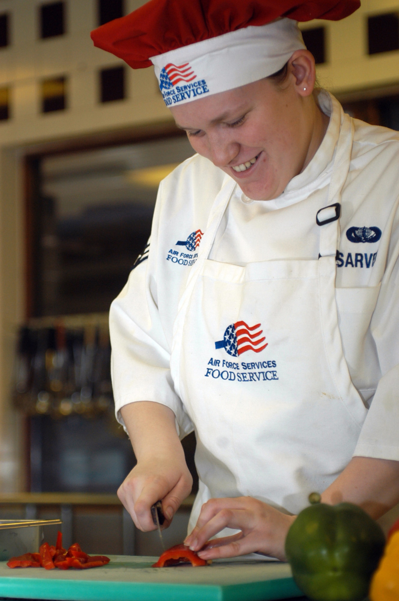 Airman 1st Class Aubrey Sarver cuts her first red bell pepper of the day as she prepares a dish to be served at the Knight’s Table dining facility. (Air Force photo by Airman 1st Class Kris Levasseur)