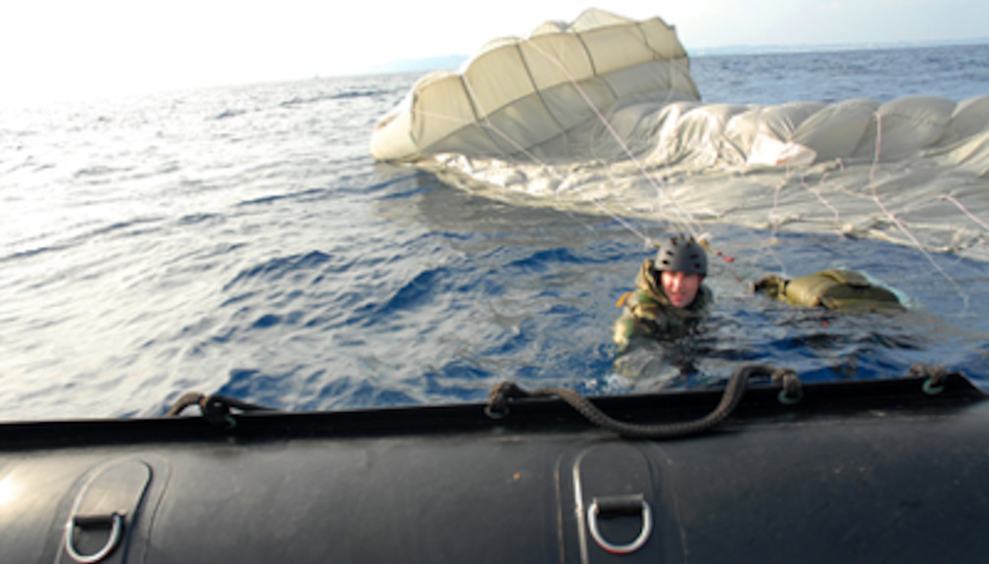 Capt. J. Harman from the 31st Rescue Squadron, Kadena Air Base, Japan, swims to the edge of a F470 Zodiac boat after jumping into the warm, blue waters of Okinawa during a weekly training exercise Jan. 16, at the White Beach Naval facility.  Pararescuemen participate in their weekly proficiency jump which keeps members current in the proper procedures of rescue and keeps them mission ready.  (U.S. Air Force photo/ Airman 1st Class Kelly Timney)