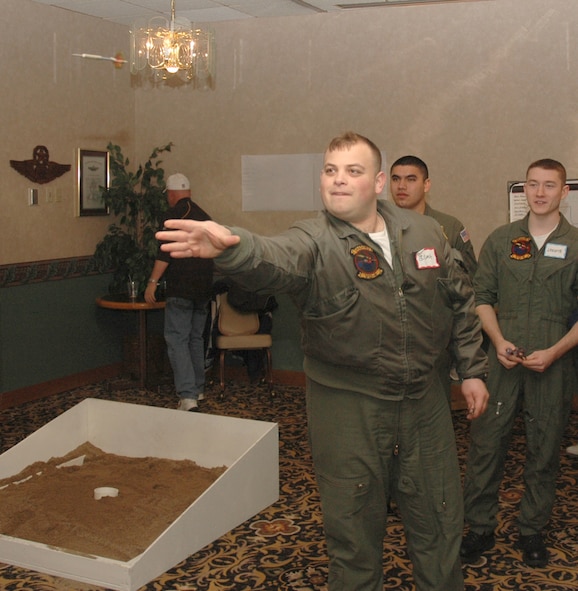 MINOT AIR FORCE BASE, N.D. -- U.S. Navy Petty Officer 2nd Class Elijah Steiner a communications specialist from VQ-4 based at Tinker Air Force Base, Okla. plays a game of darts during the 42nd annual Sportsmen’s Feed at the Jimmy Doolittle Center Jan. 21.  Petty Officer Steiner and his fellow crewmembers took part in the event after their aircraft was diverted to Minot due to inclement weather. (U.S. Air Force photo by Capt. James Bressendorff)