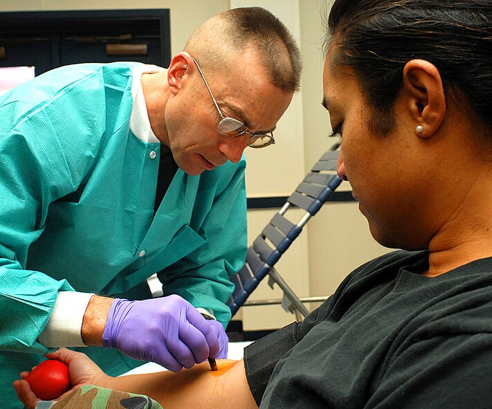 Army Staff Sgt. Joel Braymen from the William Beaumont Medical Center in Fort Bliss, Texas, disinfects Tech. Sgt. Joan Ekeroma's arm before giving blood. Sergeant Ekeroma is from the 377th Medical Group and was donating blood for the Armed Services Blood Program blood drive, which was held here Jan. 16 and Jan. 17. (U.S. Air Force photo by Todd Berenger)