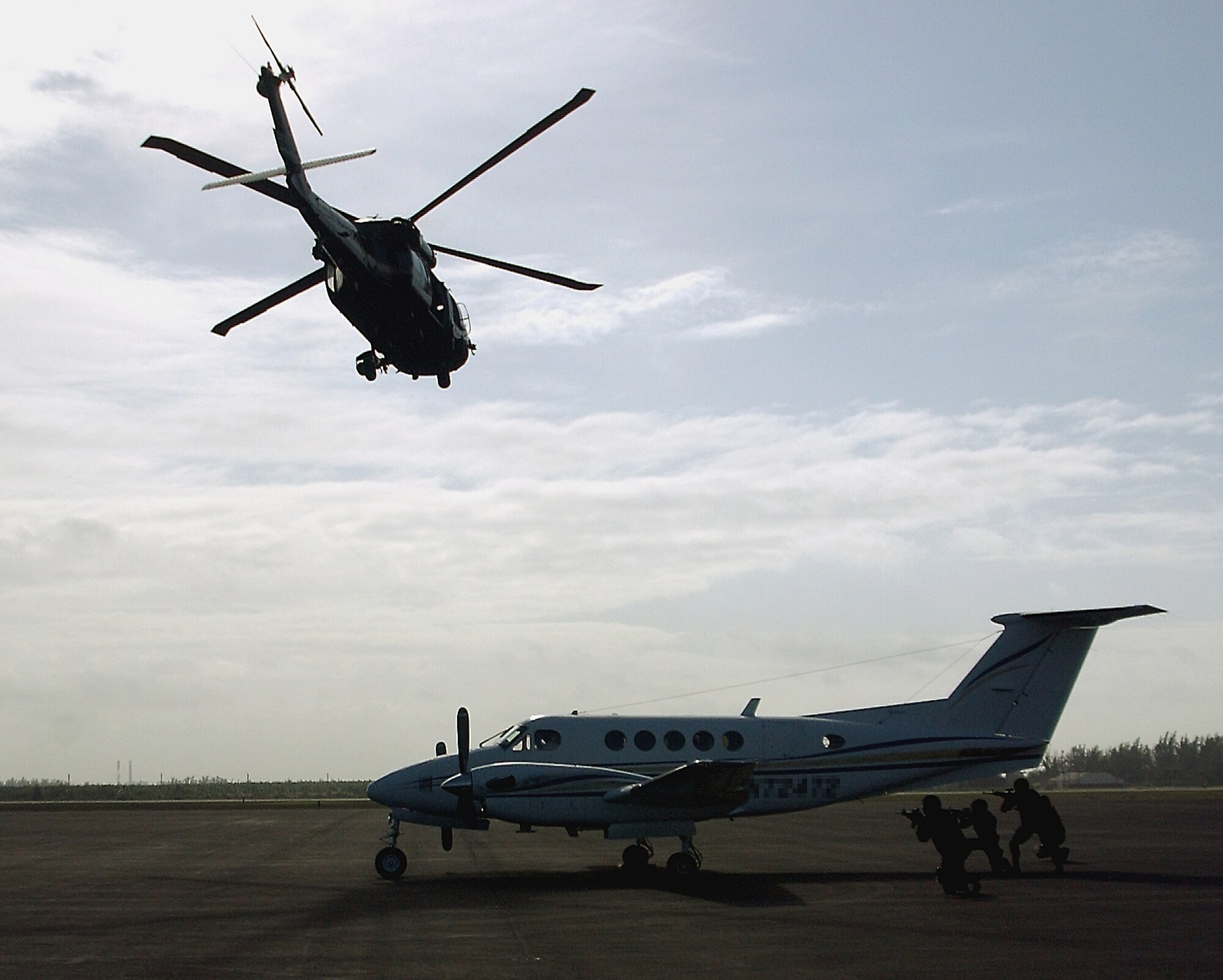 A US Customs UH-60 Blackhawk helicopter performs 360-degree aerial security as members of the Special Response Team get in place to secure an airplane during a training exercise here at Homestead Air Reserve Base, Fla. The SRT at Homestead is comprised of an all-volunteer force. (U.S. Air Force photo/Dan Galindo)
